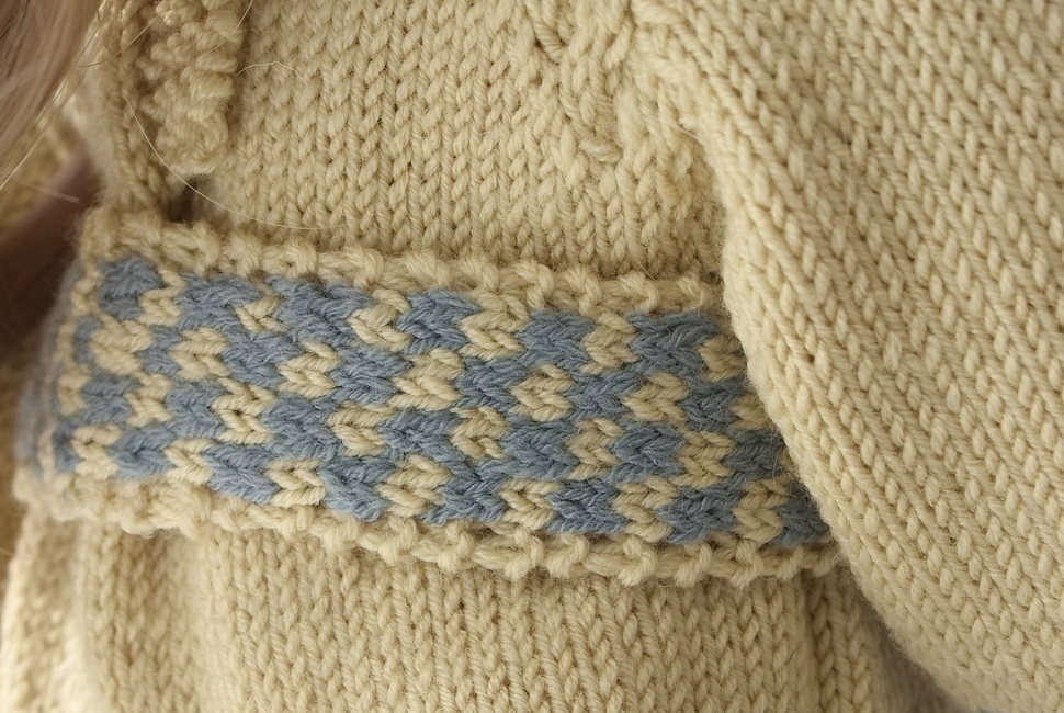 De vrolijke, <b>opgewekte ceintuur</b> met knoopdetails voegt een speelse structuur en een vleugje plezier toe aan de outfit van je Baby born-pop.