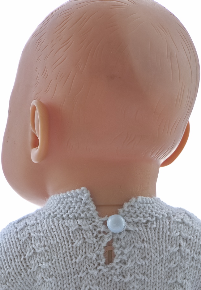 Der Pullover wird hinten geknöpft.