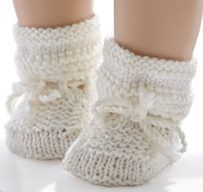 Kleine, hübsche Socken in weiß mit einem kleinen Rand, der außen um die Socken gestrickt ist, vervollständigen dieses Outfit perfekt.