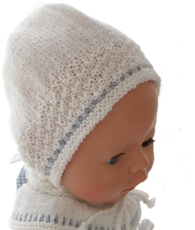 A cute bonnet knitted in white is perfect as an accessory here. The bonnet has this little pattern knitted around the front and is very cute.