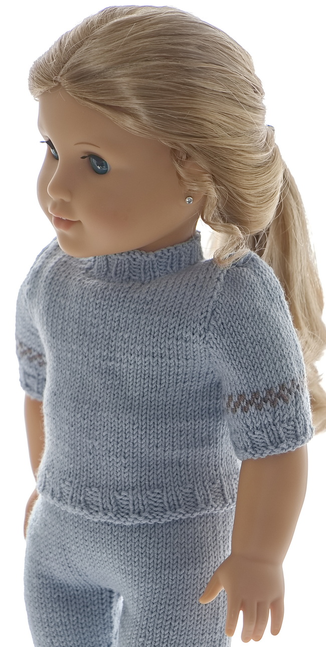 With the pants you will find a short-sleeved sweater knitted in grey with this little brown pattern around the sleeves to wear under soft and warm clothes.