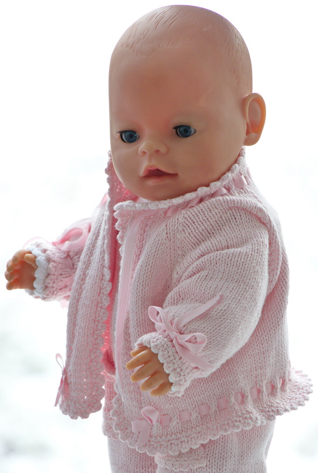 Knitted in soft pink hues, this piece showcases stocking sts adorned with eyelets, creating a delicate pattern that's both classic and whimsical.