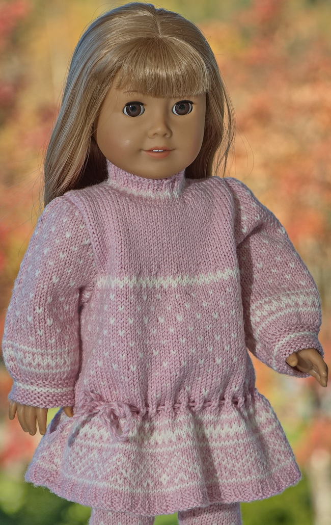 The dress is the centerpiece of this outfit. It is knitted in pink and white, with long sleeves designed to fit your doll perfectly. The pattern incorporates borders from the Norwegian Setesdal sweaters, giving it a unique and stylish look. The dress also requires one button as an accessory.